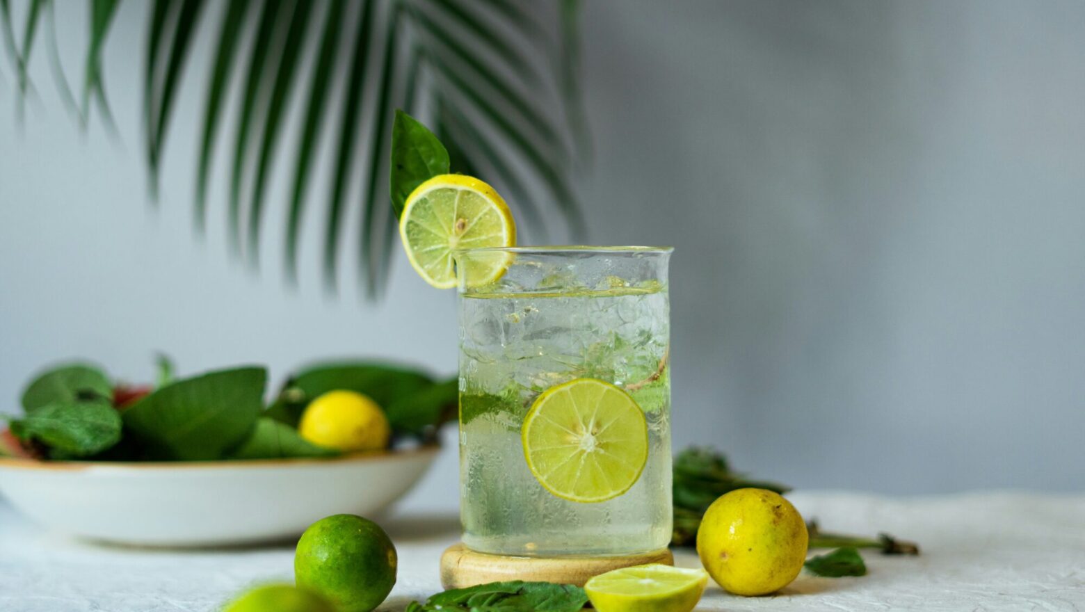 a glass of lemonade with limes and limes